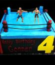 Get Ready to Rumble 4th Birthday Cake,  Blue buttercream iced,  square cake. decorated with a wrestling ring and wrestlers.  Everything on this cake is EDIBLE.  (Plastic character figurine was provided by client). (Serves 12-90 party slices)